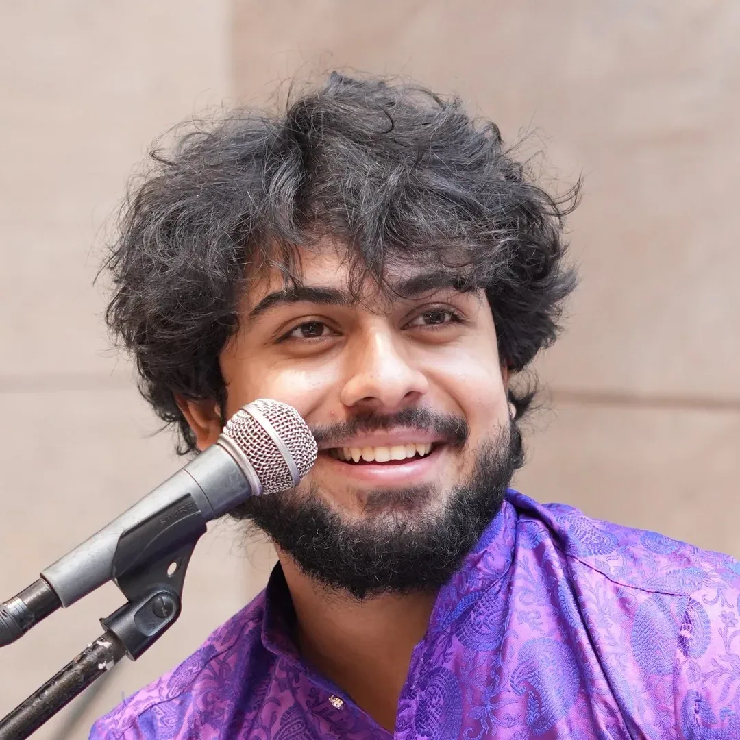 Singer Utkarsh Sharma smiling beside a microphone.